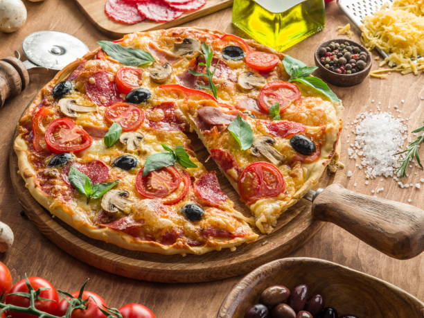 istock Pizza with mushrooms, salami and tomatoes. Top view. 866028330