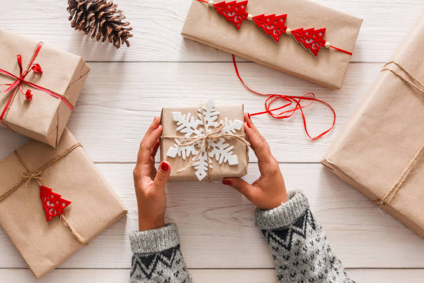 istock Woman's hands wrapping christmas holiday present with craft twine 866032356