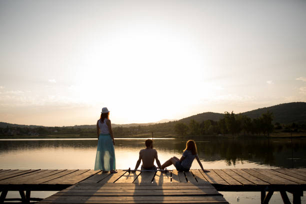 istock Friends on lake pier at sunset 866035552