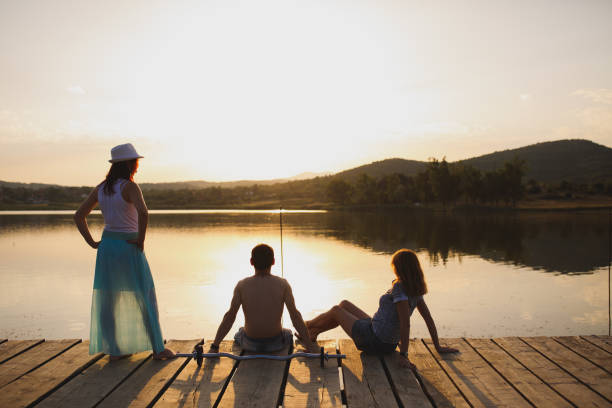 istock Friends on lake pier at sunset 866036304