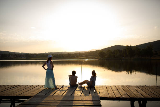 istock Friends on lake pier at sunset 866036746