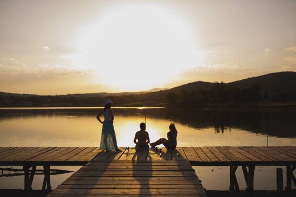 istock Friends on lake pier at sunset 866037250