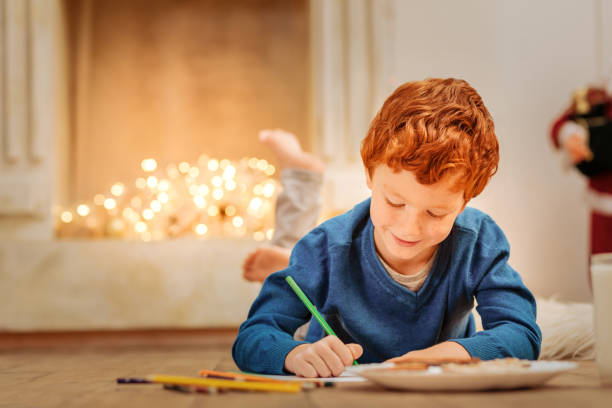Charming little boy writing letter to father christmas