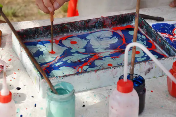 Photo of Oil-based inks in a tank of water prepared for marbling