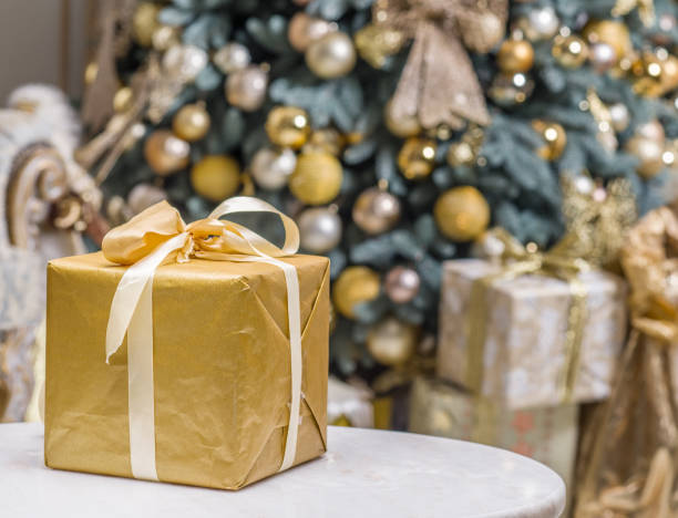 istock Yellow gift box and decorated New Year Tree on the background. 866046864