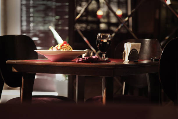 Spaghetti Carbonara served with glass of red wine in a restaurant.