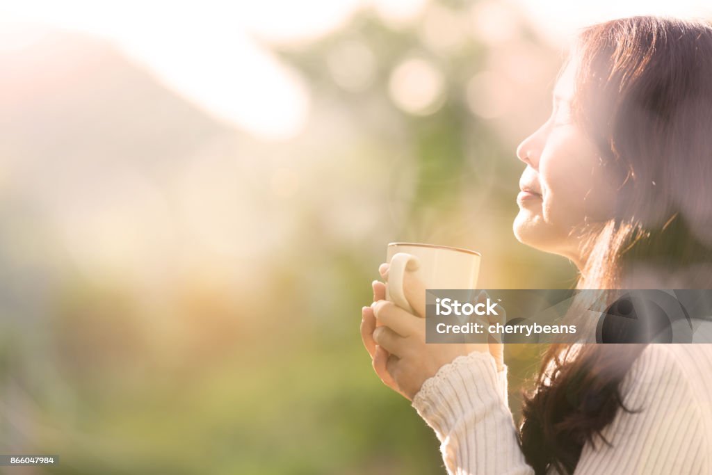 Coffee time . Woman feeling blissful with hands holding coffee cup at sunset light on the mountain, holiday lifestyle. Coffee - Drink Stock Photo