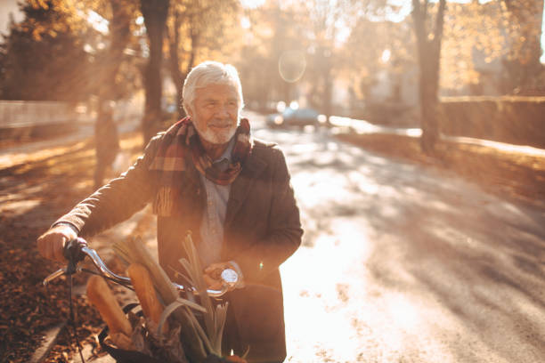 Running errands on my bike Photo of a fashionable senior man, running his errands on a bicycle man 60s bicycle stock pictures, royalty-free photos & images