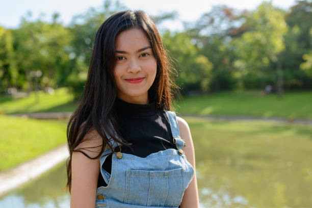 istock Young beautiful Asian woman relaxing at the park 866049310
