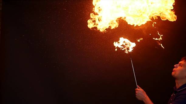 istock Fire show performance. A man picks gasoline at a torch, slow motion 866049422