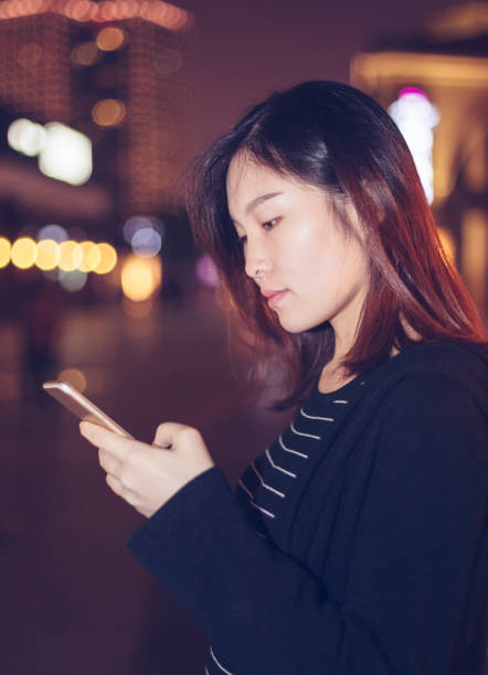 istock woman using smartphone on street at night 866049450