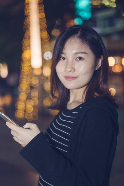 istock woman using smartphone on street at night 866049462
