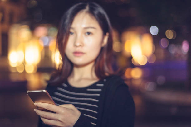 istock woman using smartphone on street at night 866049502