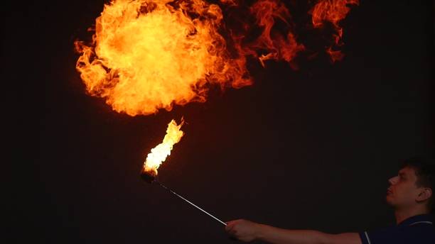 istock Fire show performance. A man picks gasoline at a torch, slow motion 866049612