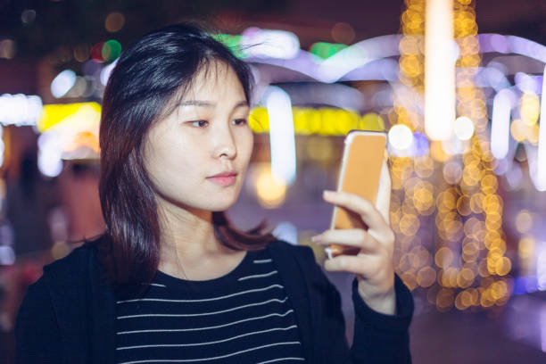 istock woman using smartphone on street at night 866050830