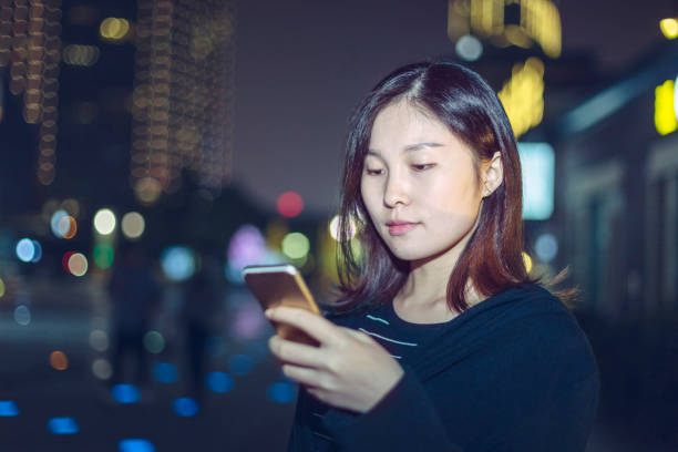 istock woman using smartphone on street at night 866052022