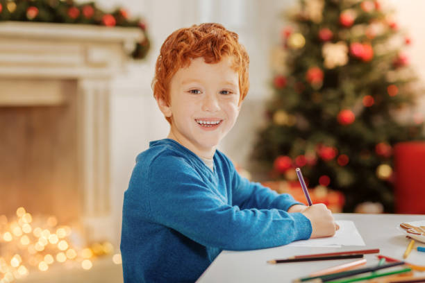 istock Radiant curly haired child smiling while drawing at home 866056142