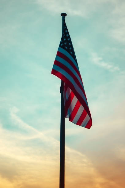 USA flag on pole in sunset