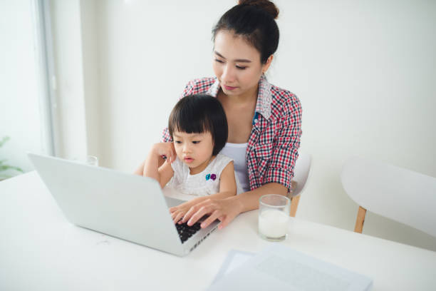 istock Asian mother woman with a her daughter working at the computer 866069218