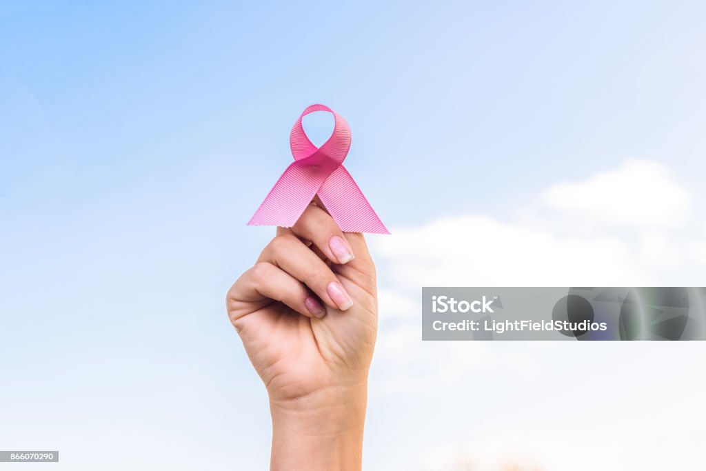 breast cancer awareness close-up partial view of hand holding breast cancer awareness ribbon Breast Cancer Stock Photo