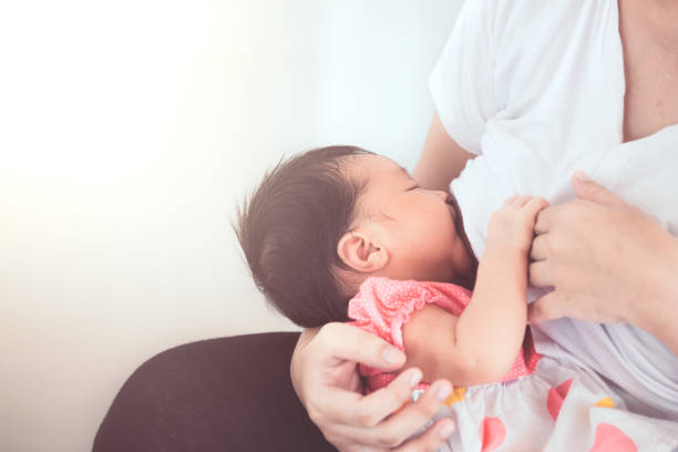 madre che allatta la sua neonata. - sucking asian ethnicity baby mother foto e immagini stock