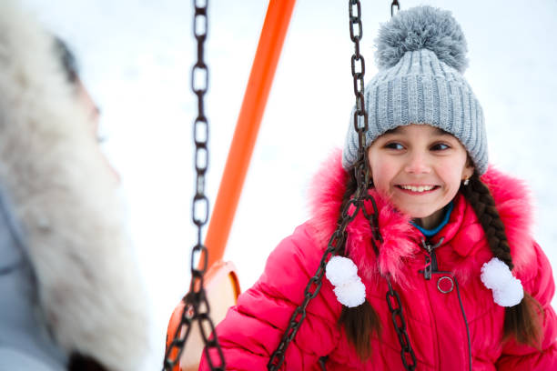 2 행복 한 여자, 어머니와 딸 겨울 서리가 내린 날에 도시 공원에 놀이터에서 그네에 앉아 - playground snow winter little girls 뉴스 사진 이미지