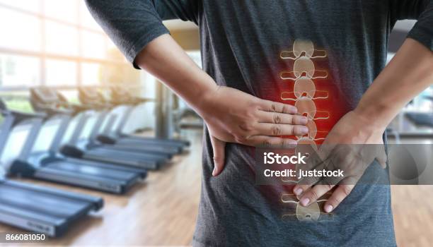 Young Man Feeling Suffering Lower Back Pain Pain Relief Concept Stock Photo - Download Image Now