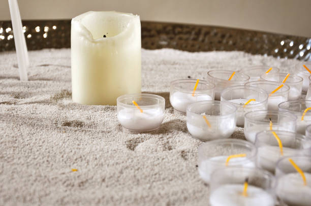 istock Many unlit candles on white sand close up. 866083766