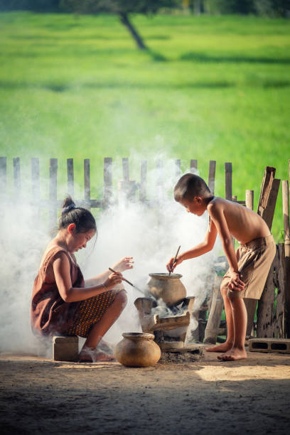 Asian children boy and girl are cooking in the Kitchen of the Countryside of Thailand, living in countryside, Countryside Thailand. Asian children boy and girl are cooking in the Kitchen of the Countryside of Thailand, living in countryside, Countryside Thailand. beautiful traditional indian girl stock pictures, royalty-free photos & images