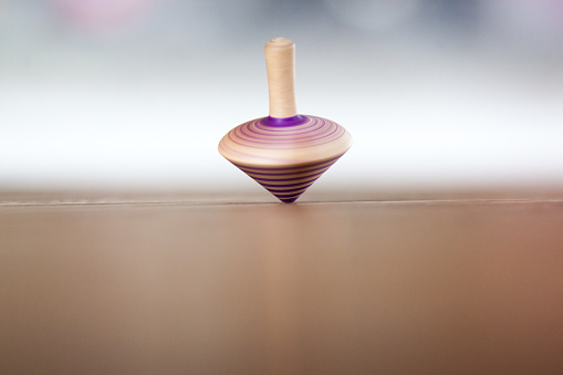 an old styled spinning top on a wooden table