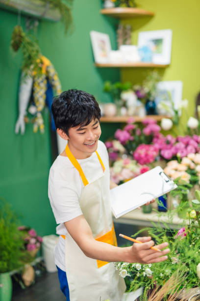 istock Busy florist drawing something in notepad at workplace 866095764