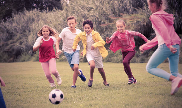 istock Kids playing football in park 866096712