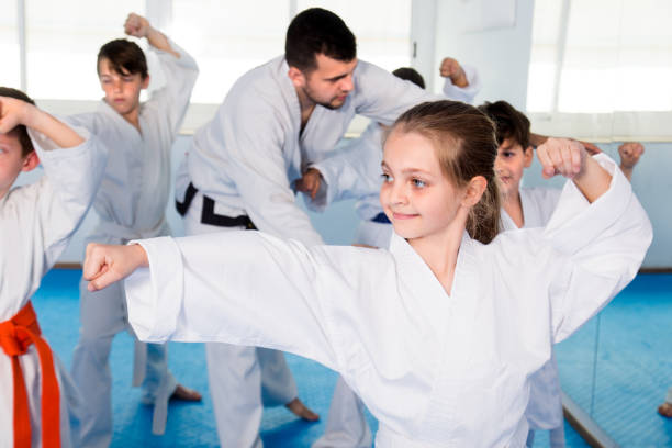 istock Young trainer is correcting children moves 866099438