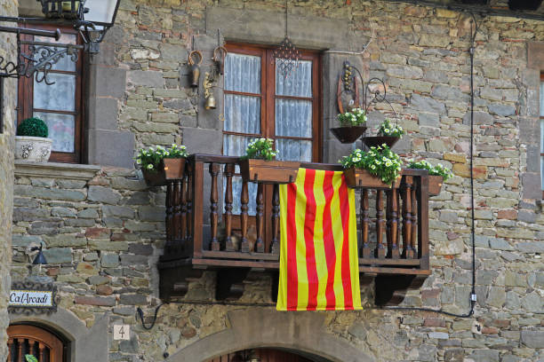 Rupit, Spain - September 09, 2014: Balcony with white petunias and Catalan flag in Rupit (Catalonia, Spain)