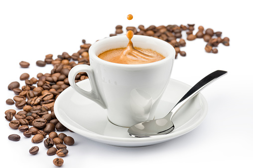 cup of coffee with splashing and beans on white background