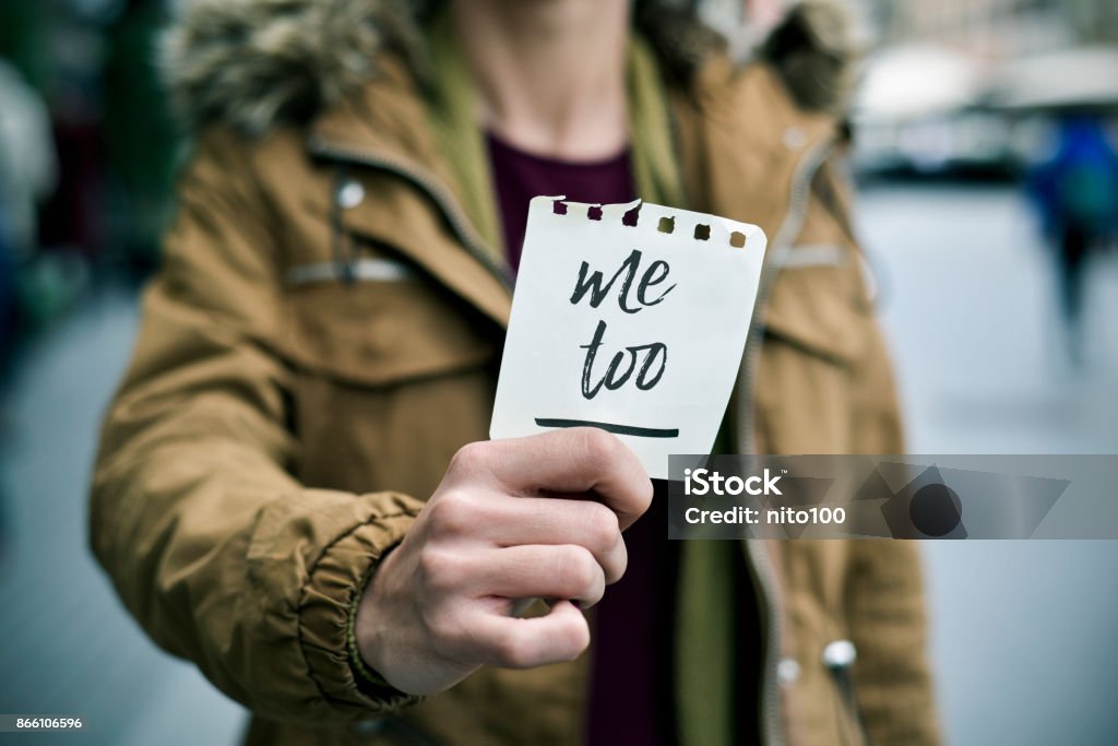 woman showing a note with the text me too closeup of a young caucasian woman in the street showing a piece of paper with the text me too written in it Me Too - Social Movement Stock Photo