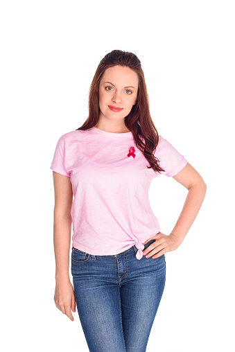 beautiful young woman in pink t-shirt with breast cancer awareness ribbon smiling at camera isolated on white