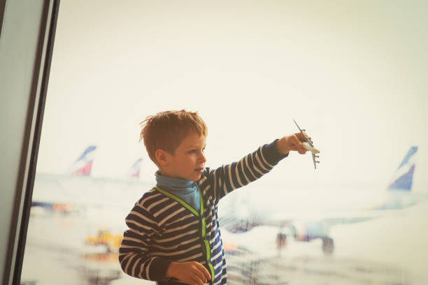 istock boy playing with toy plane while waiting in airport 866112036