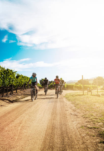 istock Cyclists riding bicycles on dirt road against sky 866119858