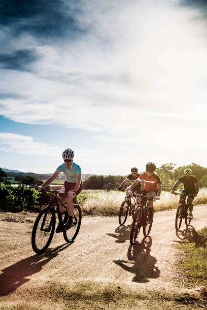 istock Cyclists riding bicycles on dirt road against sky 866120062