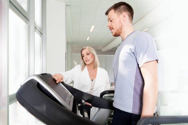 athlete on a treadmill with physiotherapist doctor - fotografia de stock