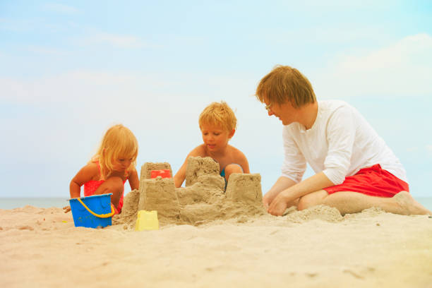 istock father with son and daughter play on beach 866124460