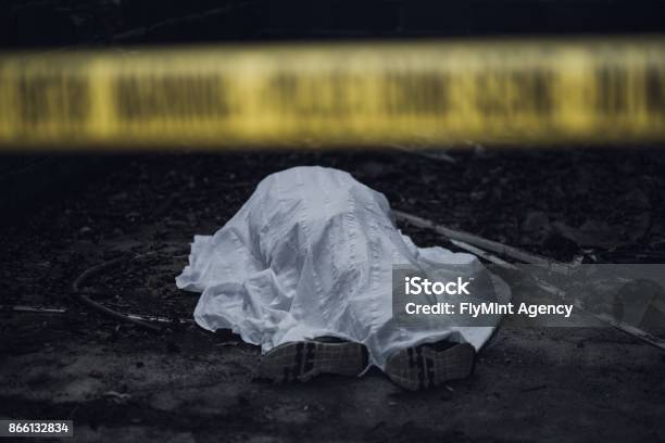 Dead Body On The Ground Behind A Cordon Tape Stock Photo - Download Image Now - Dead Person, Murder, Crime Scene
