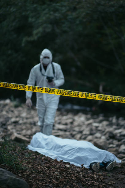istock Forensic scientist holding a camera and going towards the dead body 866132912