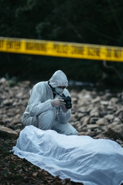 istock Forensic scientist crouching near the dead body and photographing it 866132992