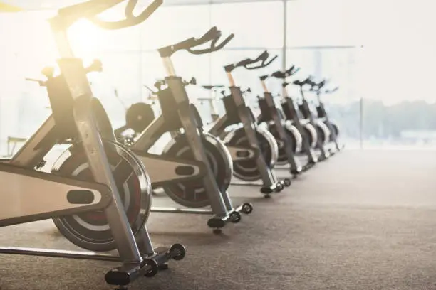 Photo of Modern gym interior with equipment, fitness exercise bikes