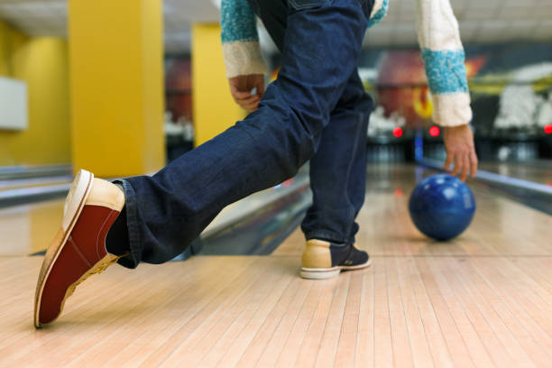 istock Man throw ball at bowling lane, cropped image 866146456