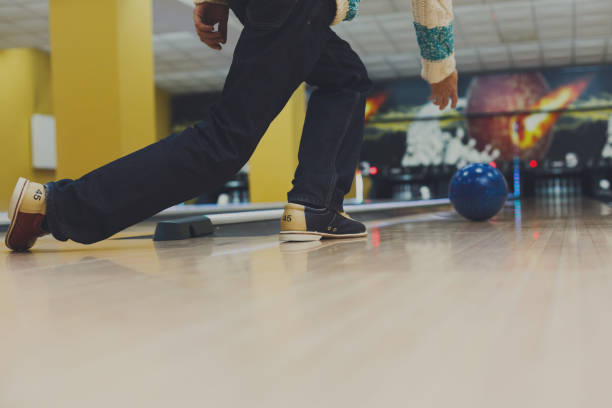 istock Man throw ball at bowling lane, cropped image 866146940