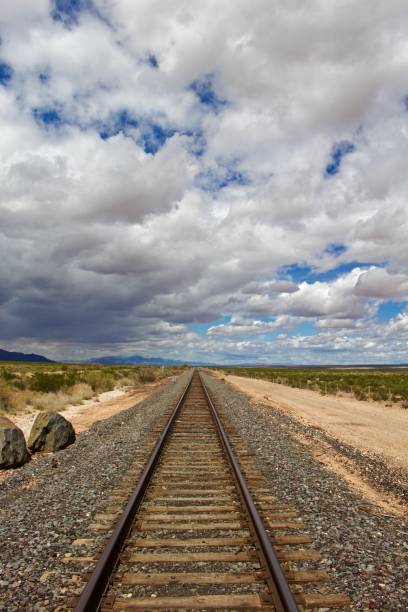 istock Train Tracks to Horizon with Cloudy Skies 866149980