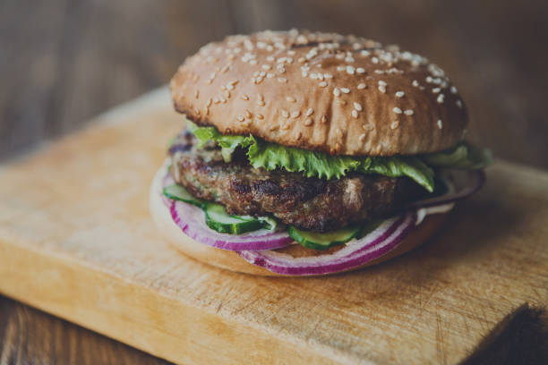 классический американский бургер, фаст-фуд на деревянном фоне - barbecue beef close up multi colored стоковые фото и изображения